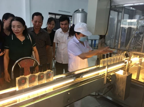 Đại diện công ty Dạ Lan và khách hàng tham quan nhà máy sản xuất rượu của Công ty CP Dạ Lan.