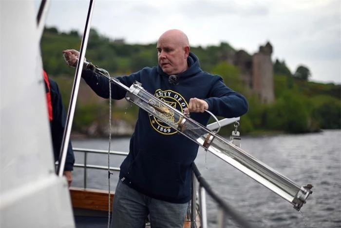Neil Gemmell lấy mẫu nước tại hồ Loch Ness. Ảnh: AFP.