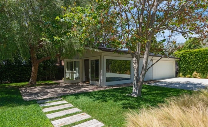 A green garden surrounds the house.