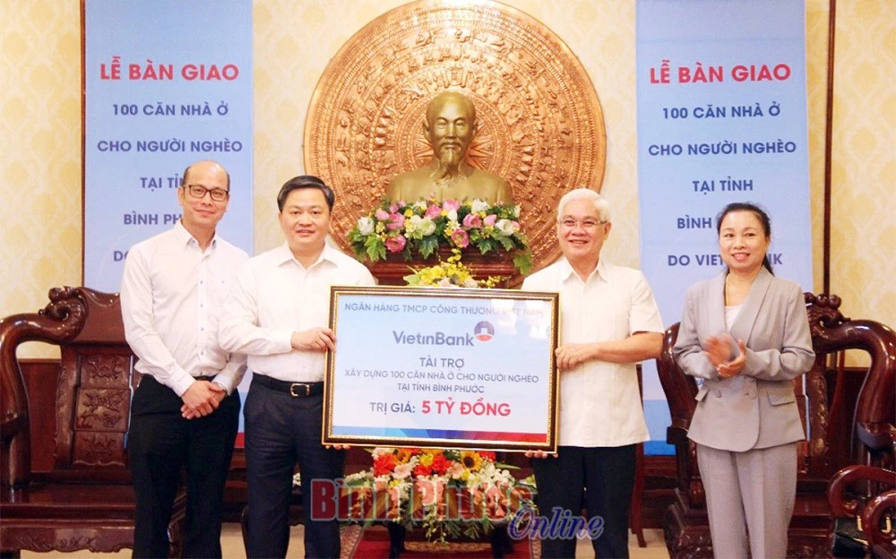Đại diện Vietinbank Việt Nam trao bảng tượng trưng bàn giao 100 căn nhà hỗ trợ người nghèo cho tỉnh Bình Phước. (Ảnh: Báo Bình Phước)