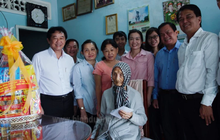 Ông Nguyễn Hoàng Thao (bìa trái) thăm, tặng quà Tết cho Mẹ Việt Nam anh hùng Trần Thị Hai.