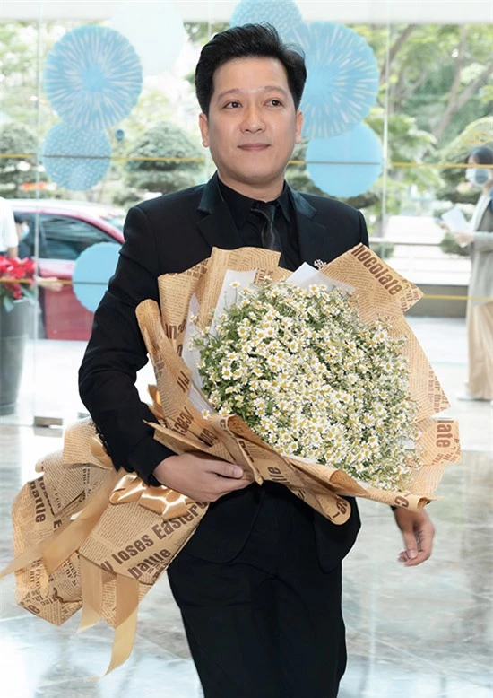 Trường Giang mặc vest bảnh bao ôm hoa đến chúc mừng vợ.