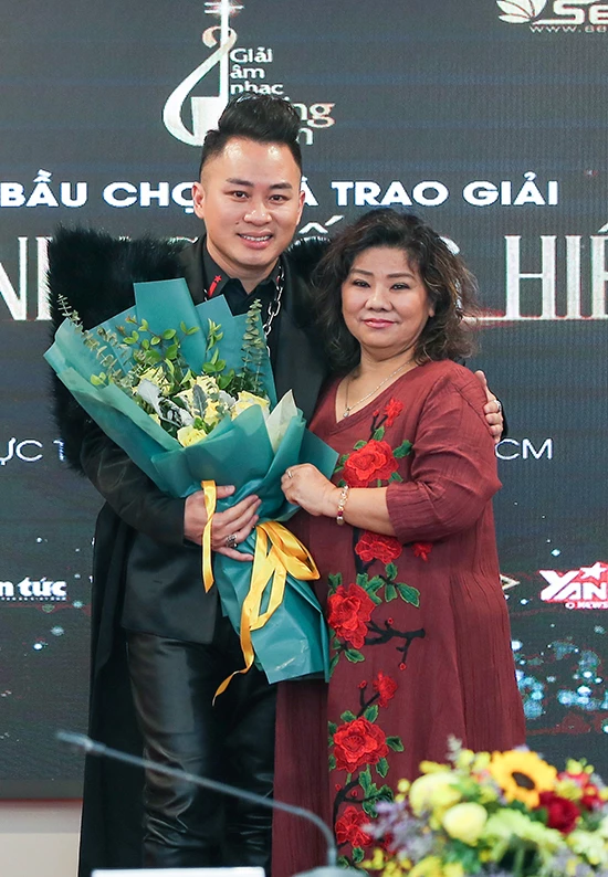 Tùng Dương nhận ba giải Cống hiến sáng 7/1. Trong ảnh, NSND Thanh Hoa trao giải Ca sĩ của năm cho anh.