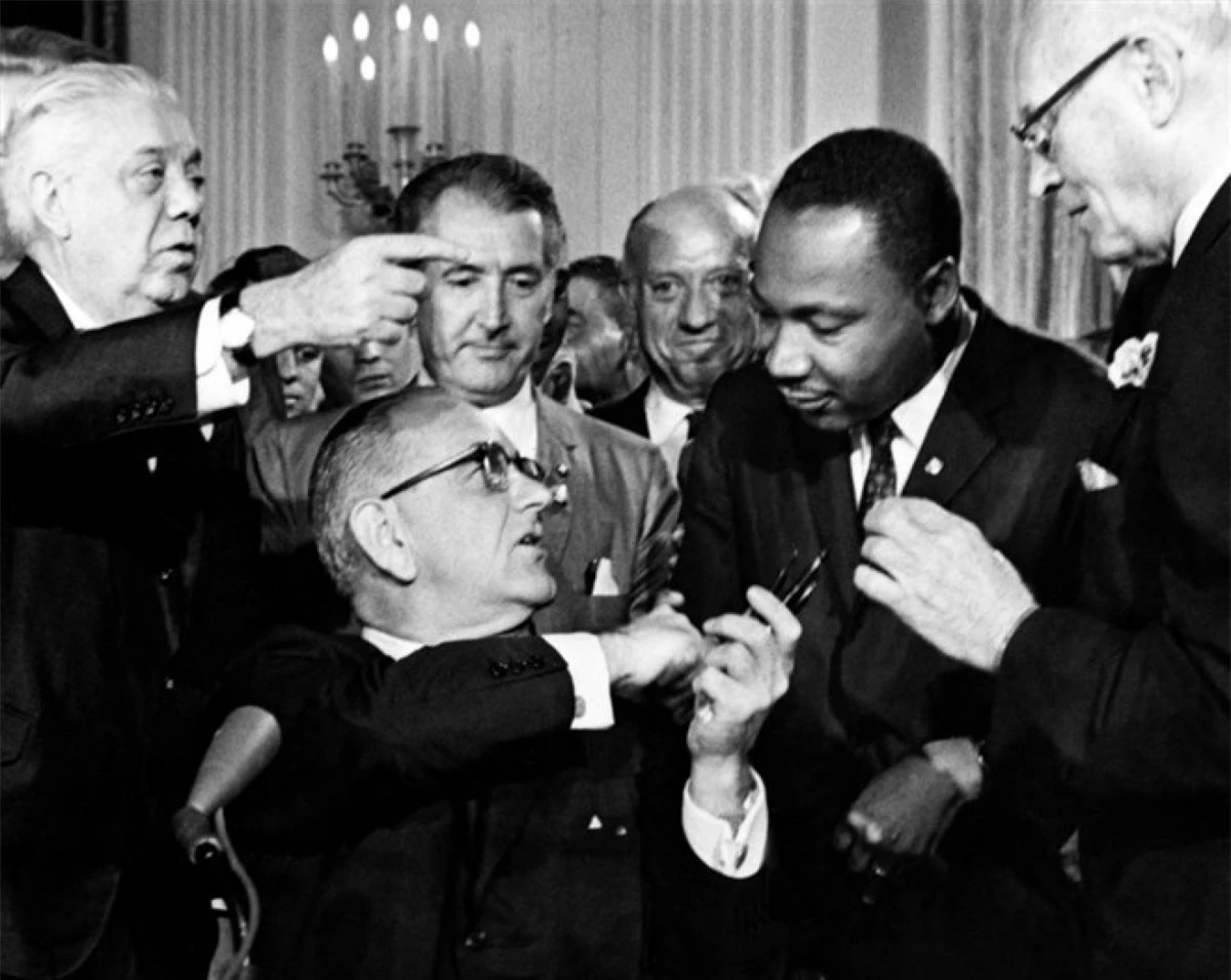 Tổng thống Lyndon B. Johnson trao bút cho ông King sau khi ký Đạo luật Dân quyền mang tính bước ngoặt vào ngày 2/7/1964 tại Nhà Trắng. Đạo luật này cấm phân biệt đối xử về chủng tộc, màu da, tôn giáo, giới tính hoặc quốc gia. Ảnh: Getty Images