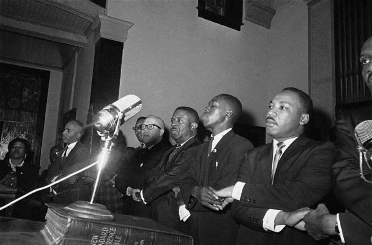 Nhà hoạt động nhân quyền King bắt tay với các nhà lãnh đạo người Mỹ gốc Phi và hát ca khúc "We Shall Overcome" tại nhà thờ ở Selma, Alabama ngày 9/3/1965. Ảnh: AP