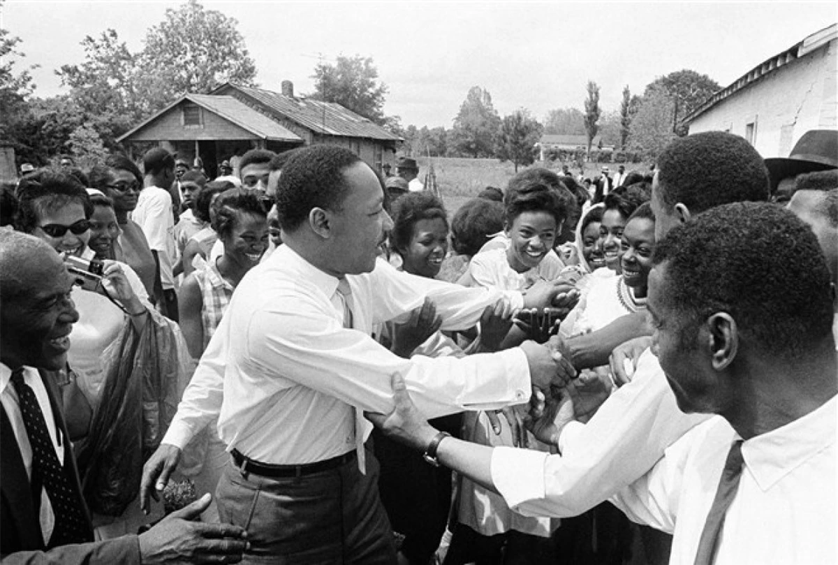 Ông King bắt tay đám đông sau khi phát biểu trong một cuộc vận động ở Lisman, Alabama ngày 30/4/1966. Lisman là 1 trong 9 điểm dừng chân của ông ở Alabama trong nỗ lực thống nhất phiếu bầu của người Mỹ gốc Phi trước cuộc bầu cử sơ bộ ở tiểu bang này. Ảnh: AP