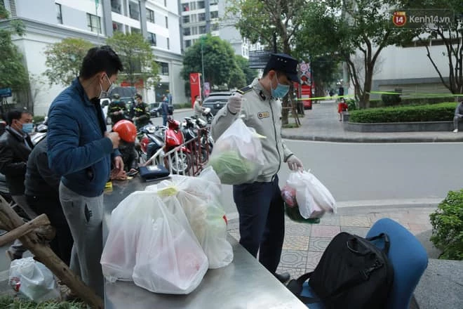 Người dân tranh thủ gửi đồ ăn thức uống và nhu yếu phẩm cho người nhà ở bên trong khu chung cư bị phong tỏa.