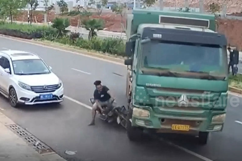 Clip: Tài xế xe máy thoát nạn sau khi ngã vào gầm xe tải