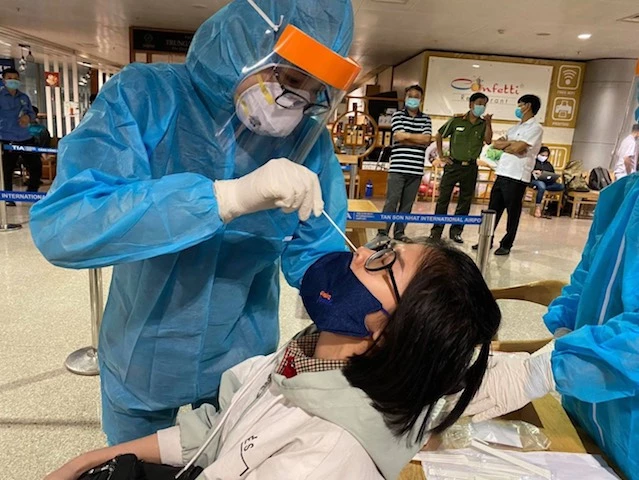 Lực lượng y tế lấy mẫu xét nghiệm tầm soát Covid-19 tại sân bay Tân Sơn Nhất. 