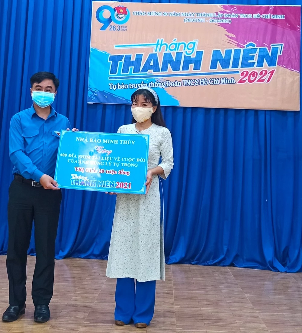 Nhà báo Minh Thùy (phải) trao bảng tượng trưng 400 đĩa phim tài liệu mang tên “Người truyền lửa” cho Bí thư Tỉnh Đoàn Bình Phước Trần Quốc Duy (trái).