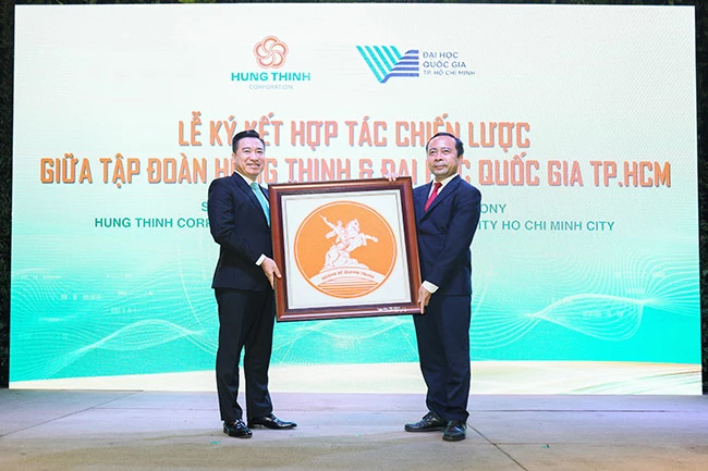 Ông Nguyễn Đình Trung, Chủ tịch Tập đoàn Hưng Thịnh trao quà lưu niệm cho PGS.TS Vũ Hải Quân, Ủy viên Trung ương Đảng, Giám đốc Đại học Quốc gia TPHCM.