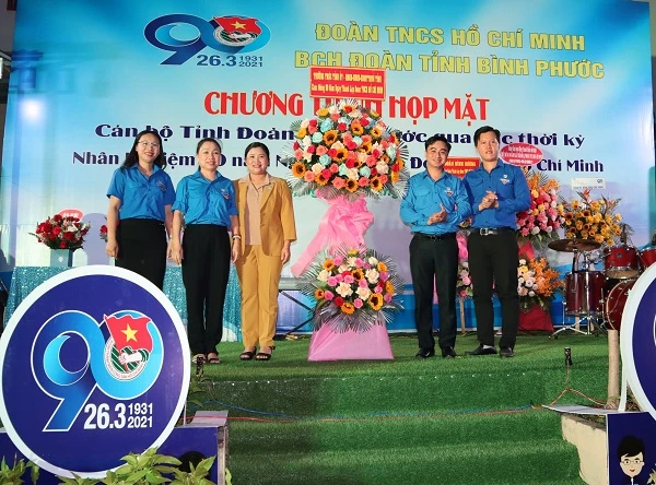 Phó Bí thư Tỉnh ủy - Chủ tịch UBND tỉnh Bình Phước Trần Tuệ Hiền (áo vàng) trao hoa chúc mừng buổi họp mặt.