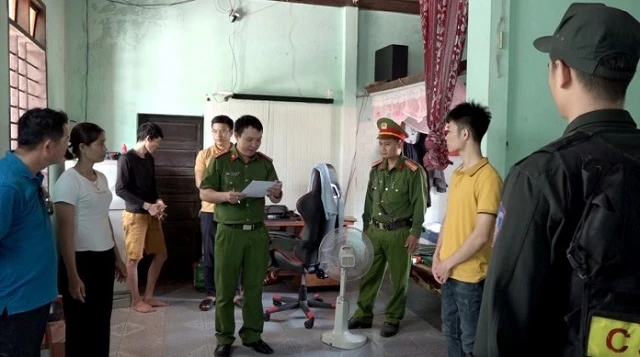 Lực lượng Công an đọc lệnh giữ người trong trường hợp khẩn cấp đối với Võ Hữu Song (áo vàng thứ 2 từ phải sang). (Ảnh: CA tỉnh Quảng Bình)