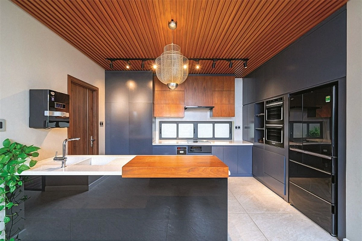 Khu bếp nấu tiện nghi được kết hợp các loại thiết bị, vật liệu hiện đại với chất liệu gỗ truyền thống mang lại vẻ ấm áp.