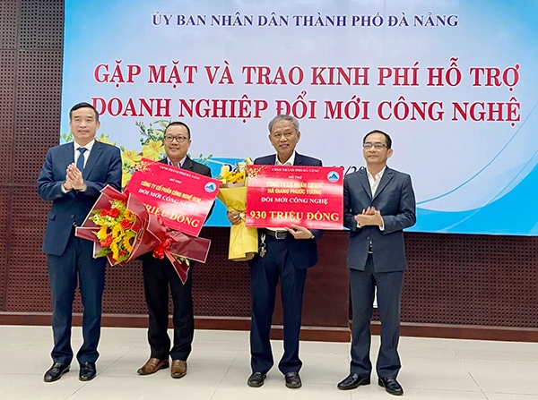 Chủ tịch UBND TP Đà Nẵng Lê Trung Chinh (bìa trái) và Giám đốc Sở KH&CN Đà Nẵng Lê Đức Viên (bìa phải) trao kinh phí hỗ trợ doanh nghiệp đổi mới công nghệ
