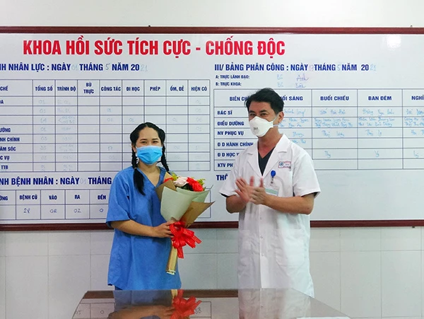 TS.BS Lê Đức Nhân, Giám đốc Bệnh viện Đà Nẵng tặng hoa chúc mừng nữ điều dưỡng sốc phản vệ sau khi tiêm vaccine Covid-19 được xuất viện ngày 17/5