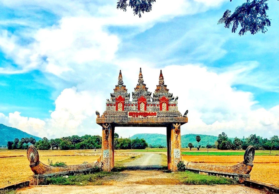Giữa đất trời An Giang, chiếc "cổng trời" với những hoa văn, chi tiết được chạm khắc tinh xảo có sức hút với khách du lịch và người dân địa phương. Công trình tọa lạc tại xã Châu Lăng, huyện Tri Tôn, là kiến trúc cổ độc đáo của người Khmer. Ngoài tên "cổng trời thời gian", "cổng trời An Giang" hay cổng chùa Koh Kas là những cách gọi khác của công trình này. Trên đường từ "cổng trời" vào chùa, bạn có cơ hội ngắm nhìn ruộng lúa vàng ươm, hàng cây thốt nốt xanh mướt hay hòa mình trên con đường làng uốn lượn quanh co... Ảnh: Daika.bao.