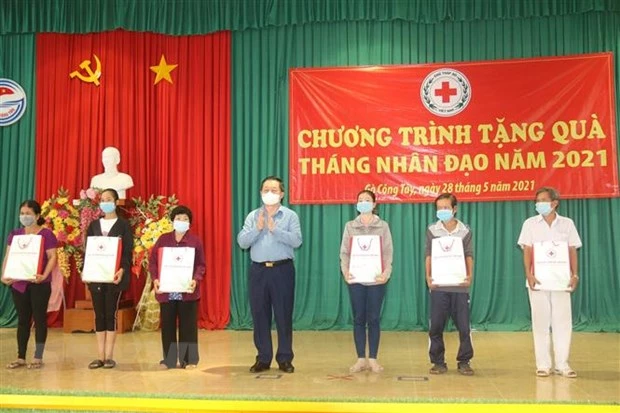 Bí thư Trung ương Đảng, Trưởng ban Tuyên giáo Trung ương Nguyễn Trọng Nghĩa tặng quà hộ nghèo. (Ảnh: Minh Trí/TTXVN)