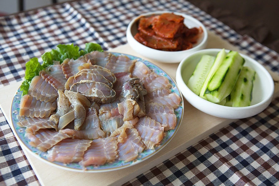 Cá đuối lên men (hongeo) là món ăn lên men có mùi khai thách thức nhiều thực khách xứ Hàn. Nhiều người miêu tả món ăn có mùi tương tự ở nhà vệ sinh công cộng. Mùi này mạnh đến nỗi có thể bám vào quần áo, tóc và da của bạn sau khi ăn. Không chỉ có mùi khó chịu, thịt cá dai và cay cũng khiến nhiều người e ngại nếm thử hongeo. Ảnh: NPR.