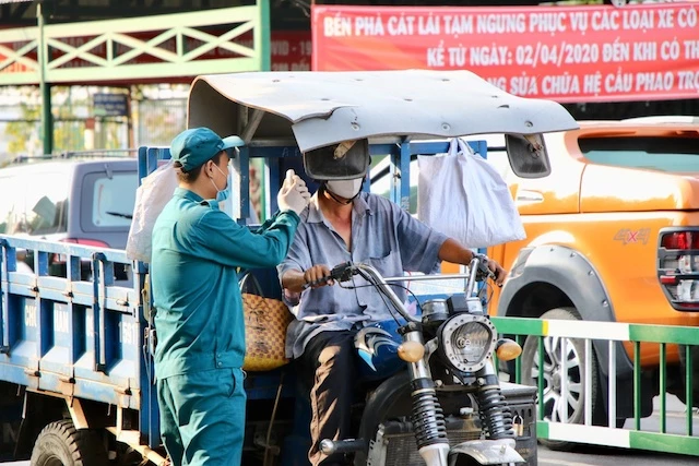 Cơ quan chức năng đo thân nhiệt người từ TP.HCM về Đồng Nai qua tuyến phà Cát Lái.