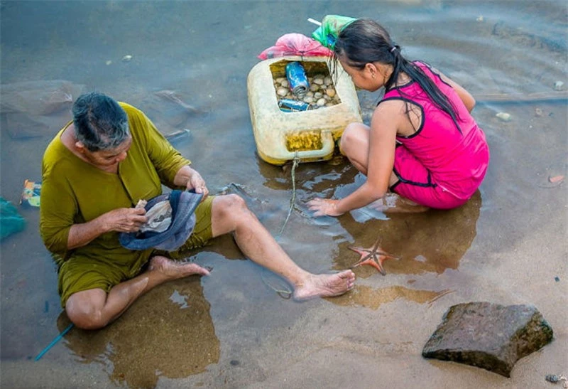 Hai ông cháu đang bắt sò. Ảnh: Tony PhamTran.