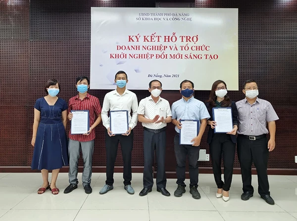 Giám đốc Sở KH&CN Đà Nẵng Lê Đức Viên (giữa) trao kinh phí hỗ trợ cho 03 doanh nghiệp khởi nghiệp đổi mới sáng tạo và Vườn ươm doanh nghiệp Đà Nẵng ngày 7/6/2021
