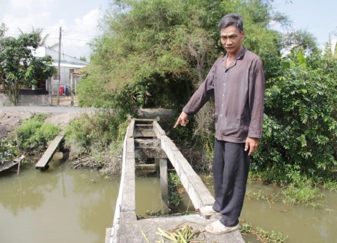 Ông Linh chỉ cây cầu bị các đối tượng dỡ đal quăng xuống kênh.