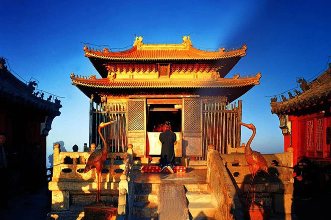 Tọa lạc trên đỉnh cao nhất của núi Võ Đang (1.612 m) là Trúc Kim Điện, biểu tượng của núi Võ Đang, được xây dựng vào năm 1416. Trúc Kim Điện được làm bằng đồng mạ vàng, nặng đến 405 tấn. Trải qua các triều đại, ngôi đền vẫn toát lên vẻ cổ kính, trầm mặc, lộng lẫy. Ngoài ra, trên núi còn có Thái Hòa Điện - khu đền thờ khổng lồ với mái ngói xanh liền kề nhau. Hoàng đế Vĩnh Lạc đã xây dựng công trình này, mô phỏng theo kiến trúc cố cung ở Bắc Kinh. Ảnh: Chinadiscovery.