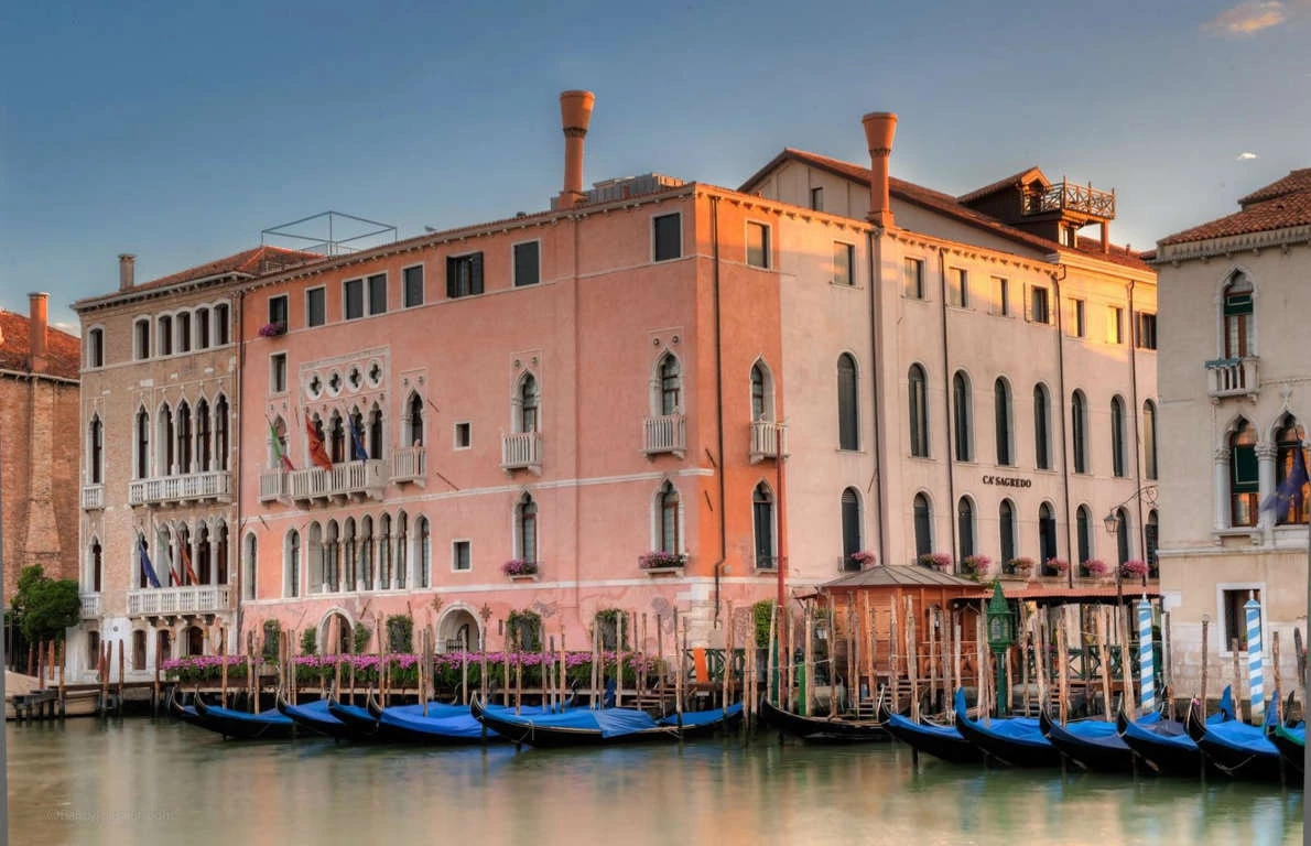 Khách sạn Ca' Sagredo, Venice, Italy: Cung điện có từ thế kỷ XV hiện là khách sạn hoàng gia, nổi bật với tông hồng ngọt ngào, view hướng ra bờ kênh Grand. Cung điện được một gia đình quý tộc danh giá mua vào thế kỷ XVII, trước khi mở cửa như khách sạn hạng sang vào năm 2007. Các phòng suite được giới thượng lưu ưa chuộng bởi những chi tiết mạ vàng, chạm khắc tinh xảo, gối bọc nhung và họa tiết sang trọng.