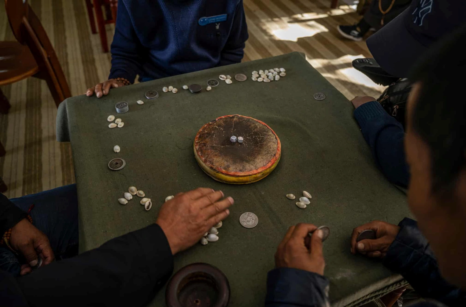 Những người này đang chơi một trò chơi truyền thống của Tây Tạng tại viện dưỡng lão Caigongtang. Trò này có tên là "sho" và thường được những người đàn ông chơi cược tiền.