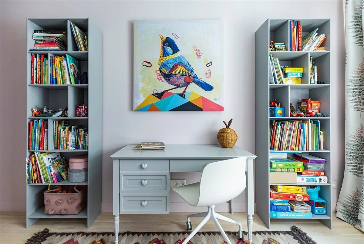 Bức tranh đa màu sắc cùng kệ lưu trữ lớn được bố trí xung quanh bàn học tập nhỏ đã tạo nên một không gian thư giãn và tuyệt đẹp.