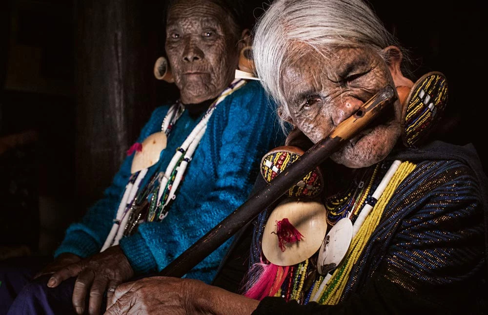 Hơn 100 dân tộc khác nhau cư trú ở Myanmar. Trong đó, dân tộc Chin có khoảng 1,5 triệu người và được chia thành 37 nhóm. Chỉ phụ nữ lớn tuổi của một số bộ lạc Chin mới có những hình xăm trên khuôn mặt. Theo nhiếp ảnh gia Michi, việc truyền thống độc đáo này biến mất chỉ còn là vấn đề thời gian.