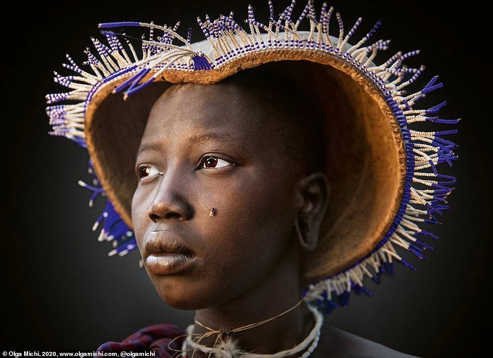 Tác giả Olga Michi miêu tả bức ảnh này thể hiện sự kết hợp của thời trang Đông Phi ngày nay với châu Âu thế kỷ 18. Con ruồi trên mặt của người phụ nữ Mursi trong hình được cho là gợi nhớ đến những miếng dán làm đẹp (gọi là "mouches") phổ biến vào thời điểm đó, đặc biệt là ở Pháp.