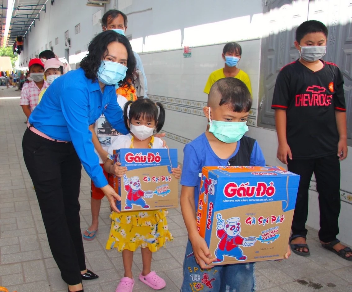 Chị Mai Tuyết Ngọc, Giám đốc Trung tâm Hoạt động thanh thiếu nhi tỉnh trao quà cho con em thanh niên công nhân có hoàn cảnh khó khăn ở khu nhà trọ tại xã Minh Hưng (H. Chơn Thành)