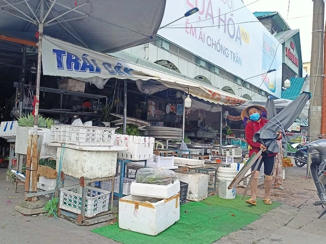  Một tiểu thương chợ Xuân Khánh đang dọn dẹp hàng hóa sau thông báo tạm dừng hoạt động của chợ.