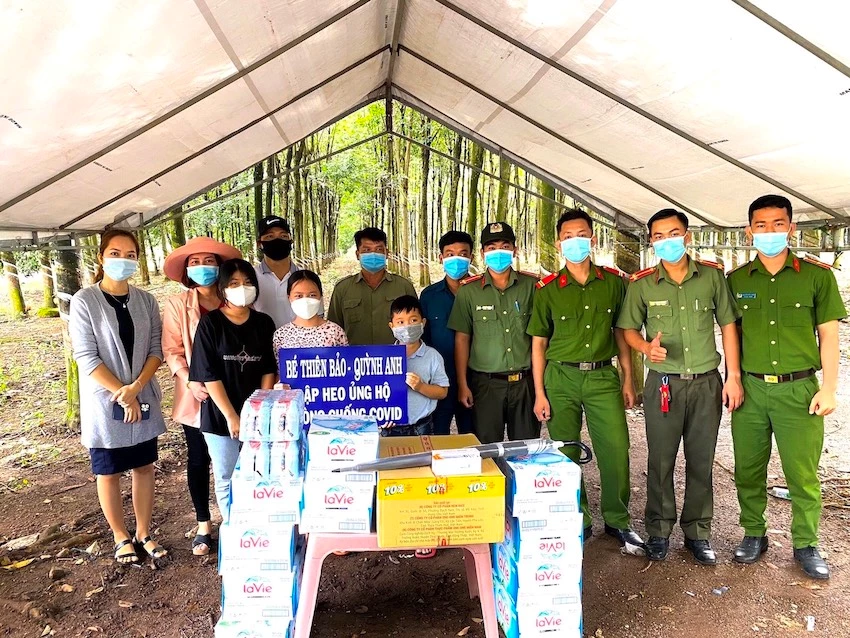 Từ phải sang, anh Phạm Huy Hùng - Bí thư Chi đoàn CA huyện Đồng Phú (thứ 2), các bé Nguyễn Thiên Bảo (thứ 6), Đặng Quỳnh Anh (thứ 8), Vũ Ngọc Hà Vy (thứ 9) tặng quà cho chốt kiểm soát dịch tại xã Tân Lập do Công an huyện lập