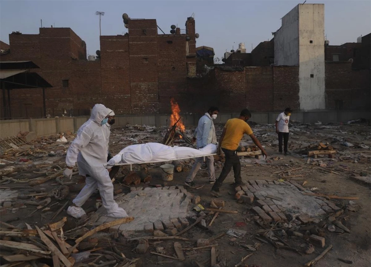 Các thành viên gia đình và tình nguyện viên mang thi thể của một bệnh nhân tử vong do Covid-19 đi hỏa táng ở New Delhi, Ấn Độ. Ảnh: AP