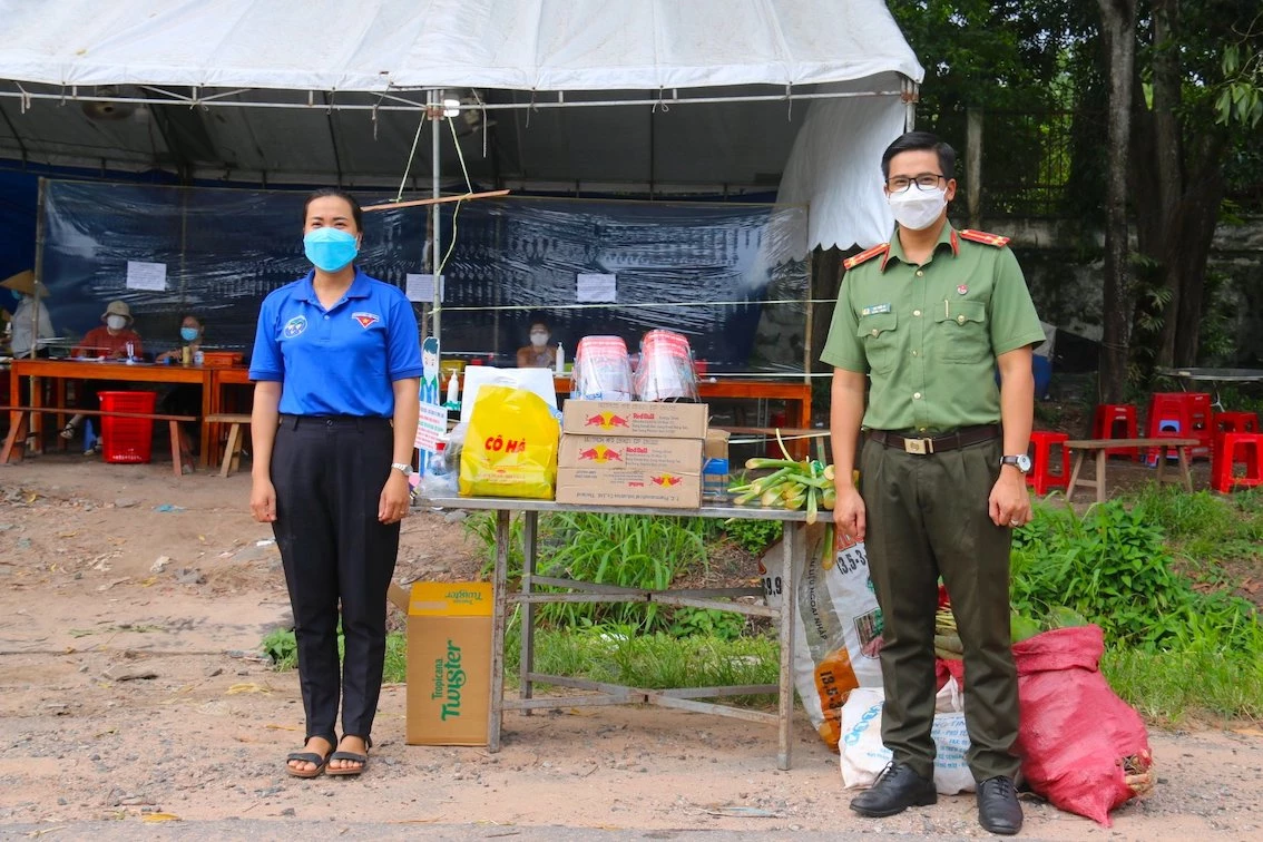 Thường trực BCH Đoàn Thanh niên Công an tỉnh - Thượng úy Lại Tiến Sĩ (bên phải) trao quà cho chốt kiểm soát liên ngành ở xã Minh Long (H.Chơn Thành)