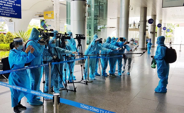 Các phóng viên tuân thủ giãn cách khi đưa tin các chuyến bay đưa người dân Đà Nẵng từ TP Hồ Chí Minh trở về