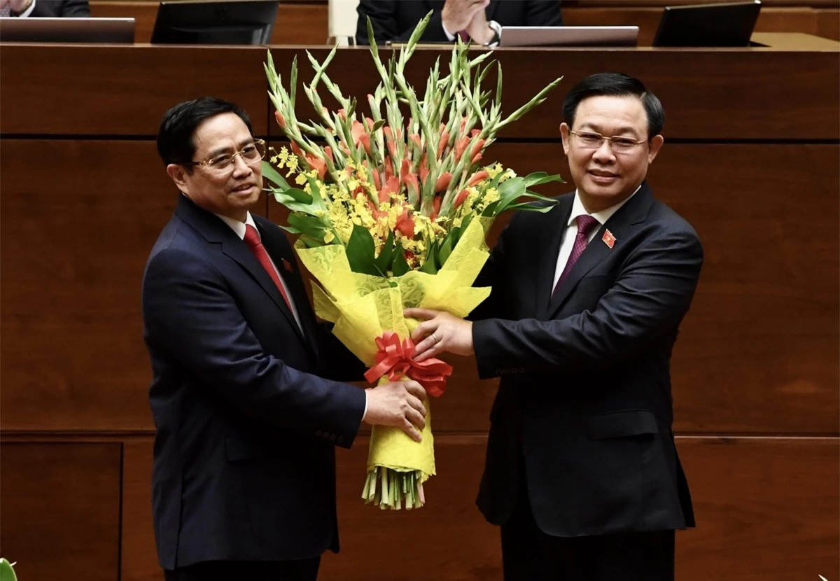 Thủ tướng Phạm Minh Chính nhận hoa từ Chủ tịch Quốc hội Vương Đình Huệ tại lễ tuyên thệ nhậm chức.