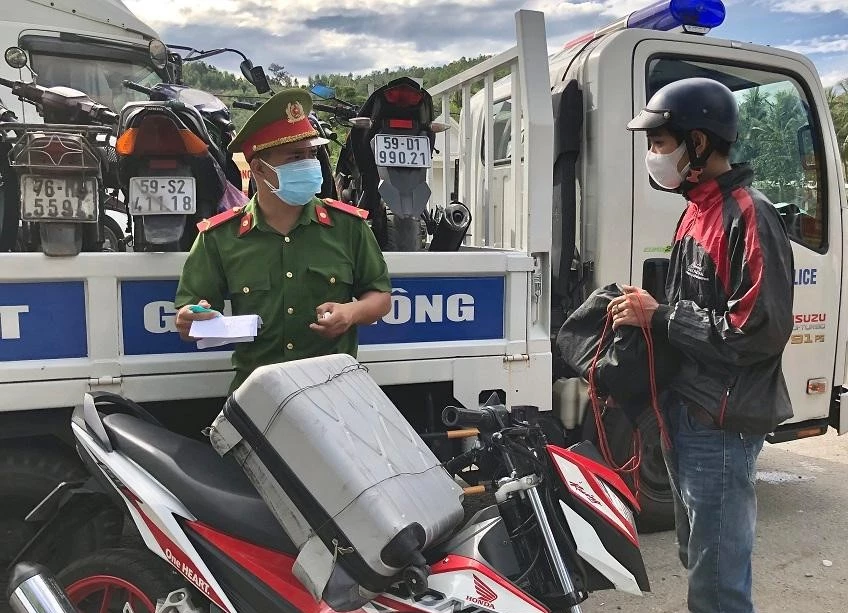 Người dân đi xe máy từ TP. Hồ Chí Minh về quê đang kiểm tra y tế tại chố trên địa phận tỉnh Quảng Ngãi