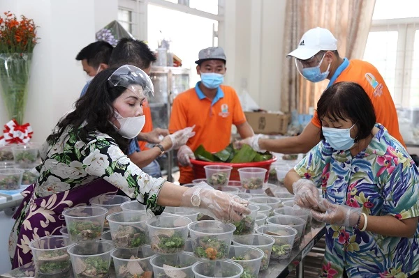 1.Bà Kim Oanh (ngoài cùng bên trái) đang chuẩn bị suất ăn để tặng lực lượng chống dịch tại quận Gò Vấp TP.HCM.
