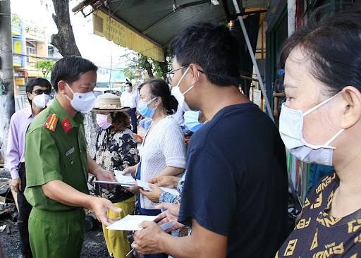Trung tá Nguyễn Đức Hậu, Trưởng Công an TP Long Xuyên trao tiền hỗ trợ cho 5 hộ dân có nhà bị cháy.