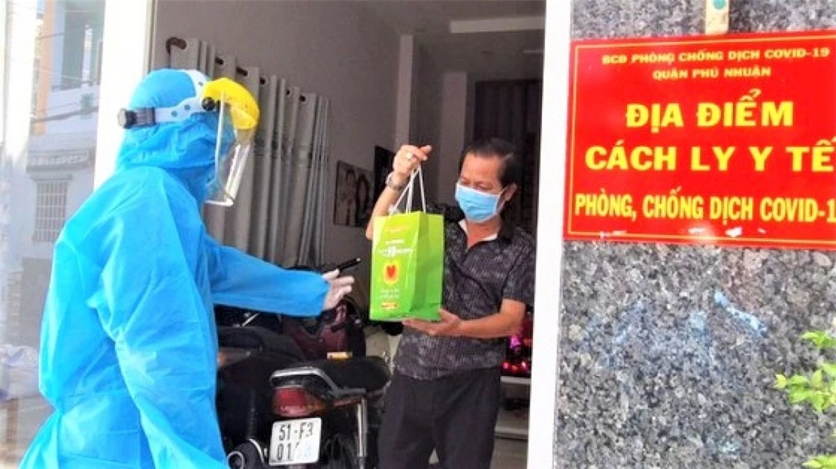 Đội hình "Đồng hành cùng F0 khỏi bệnh" trao túi thuốc và hướng dẫn bệnh nhân F0 đang điều trị tại nhà ở quận Phú Nhuận. (Ảnh: HCDC).