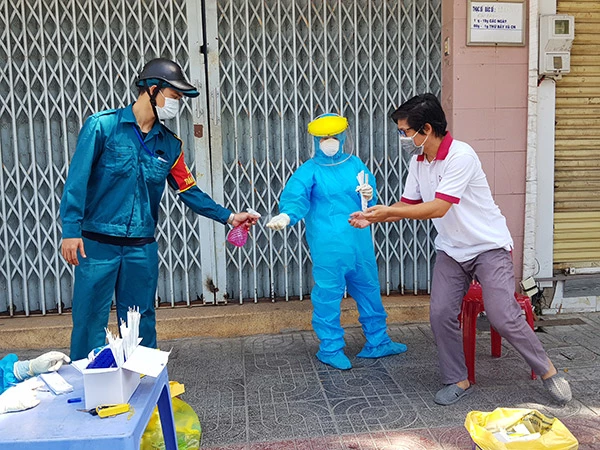 Nhân viên lấy mẫu xét nghệm của Trung tâm Y tế quận Thanh Khê và người dân phường Tân Chính đều tuân thủ việc sát khuẩn tay trước và sau khi lấy mẫu xét nghiệm