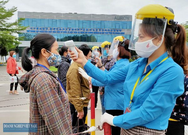 Các thành viên Tổ An toàn Covid-19 của Công ty TNHH Giầy Aleron Thanh Hóa kiểm tra thân nhiệt cho CNLĐ trước khi vào nhà máy