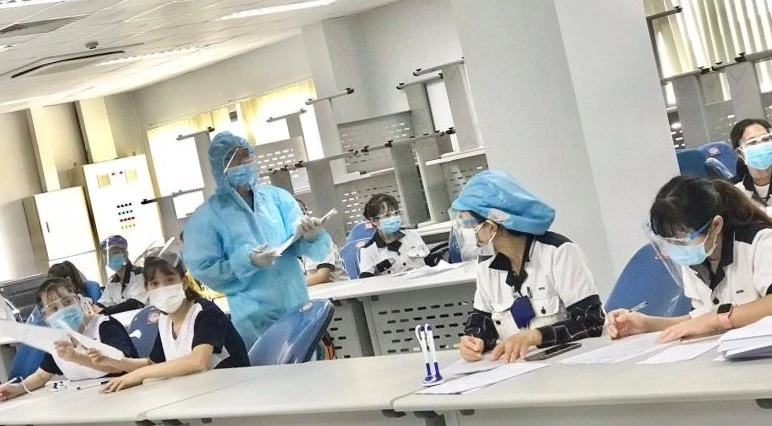 Nhân viên y tế đang thu thập thông tin, điều tra dịch tễ với người lao động đang làm việc tại Công ty Hoya Lens Việt Nam