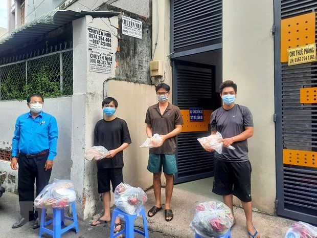 Đại diện Liên đoàn Lao động TP Hồ Chí Minh trao quà cho công nhân lao động gặp khó khăn đang ở trọ tại phường Bình Thọ, thành phố Thủ Đức. (Ảnh: Thanh Vũ/TTXVN)