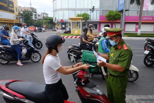 Lực lượng chức năng kiểm tra giấy đi đường của người dân. 