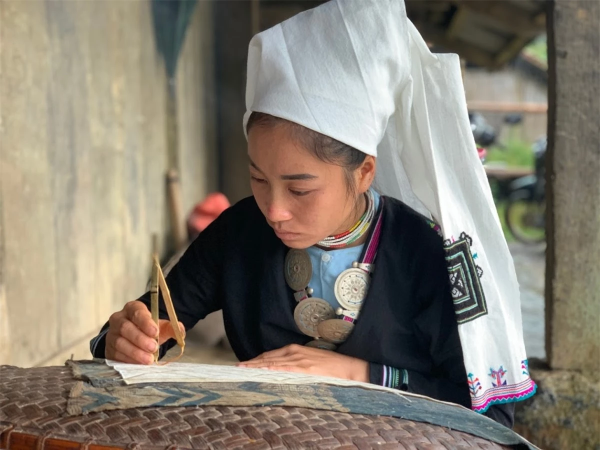 Phụ nữ Dao Tiền dùng sáp ong để in hoa văn lên trang phục truyền thống.